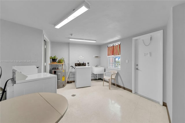 laundry room featuring electric water heater, sink, and washing machine and clothes dryer