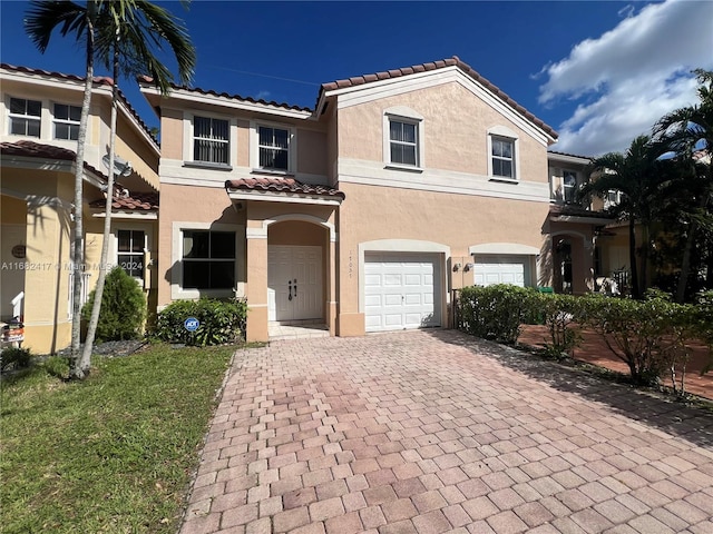 mediterranean / spanish home with a garage and a front yard