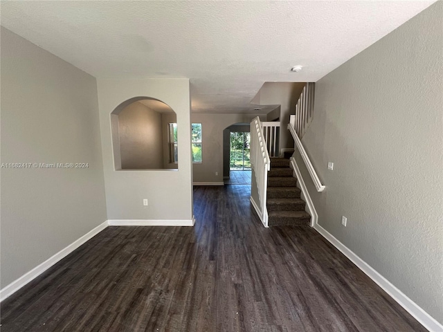 interior space with dark wood-type flooring and a textured ceiling