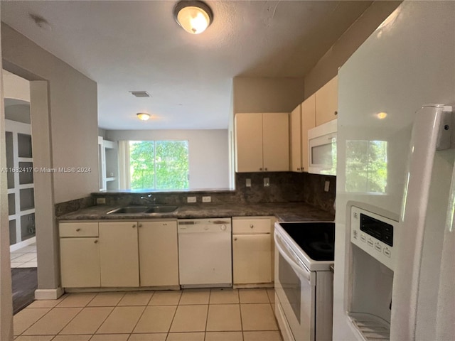 kitchen featuring sink, white appliances, backsplash, and light tile patterned floors