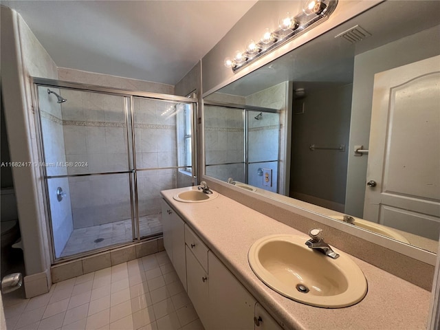 bathroom featuring vanity, tile patterned floors, and a shower with door