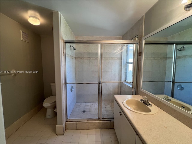 bathroom featuring vanity, walk in shower, tile patterned flooring, and toilet