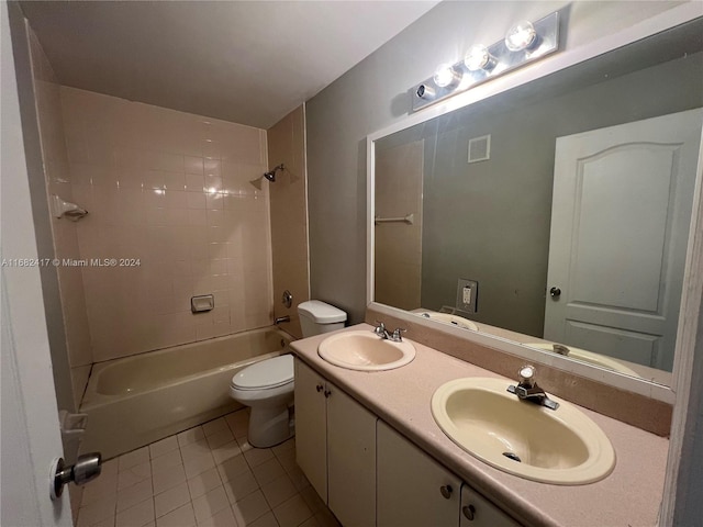 full bathroom featuring toilet, vanity, tiled shower / bath, and tile patterned flooring