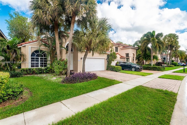 mediterranean / spanish-style house featuring a front lawn and a garage