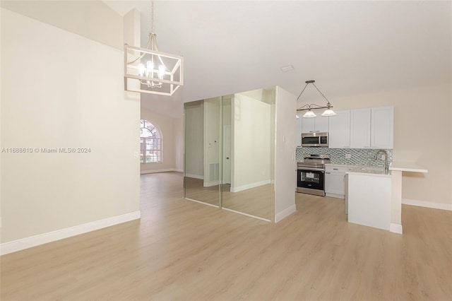 kitchen featuring white cabinets, pendant lighting, appliances with stainless steel finishes, and light wood-type flooring