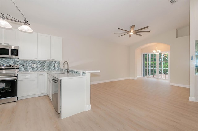 kitchen featuring stainless steel appliances, white cabinets, pendant lighting, and kitchen peninsula