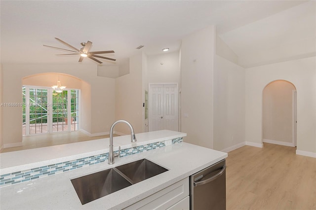 kitchen with light hardwood / wood-style floors, vaulted ceiling, dishwasher, sink, and light stone countertops