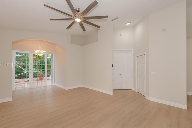 empty room featuring light wood-type flooring and ceiling fan with notable chandelier