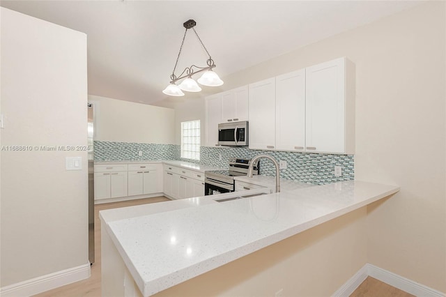 kitchen with stainless steel appliances, white cabinetry, sink, kitchen peninsula, and pendant lighting