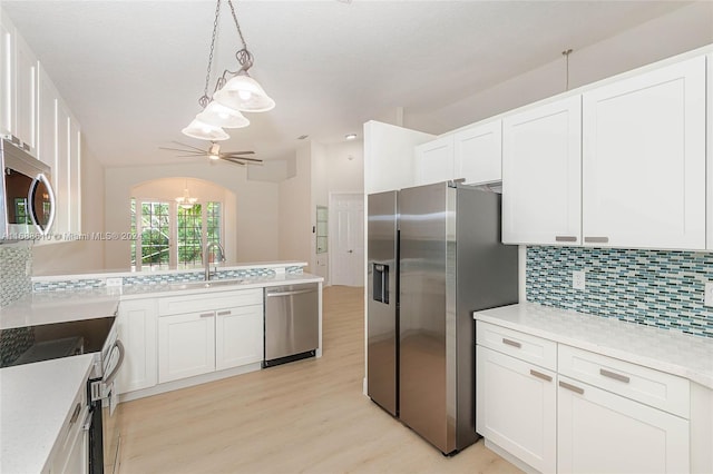 kitchen featuring light hardwood / wood-style flooring, tasteful backsplash, white cabinetry, and stainless steel appliances