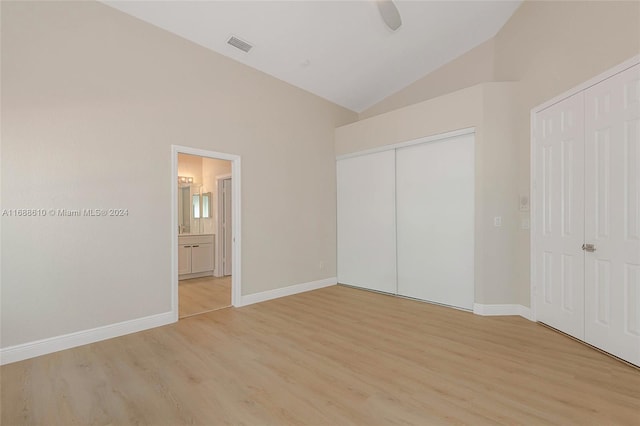 unfurnished bedroom featuring connected bathroom, lofted ceiling, ceiling fan, and light hardwood / wood-style flooring