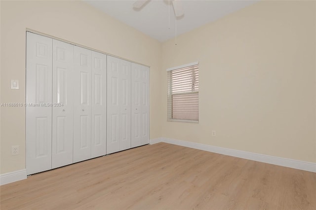 unfurnished bedroom featuring light hardwood / wood-style floors, ceiling fan, and a closet