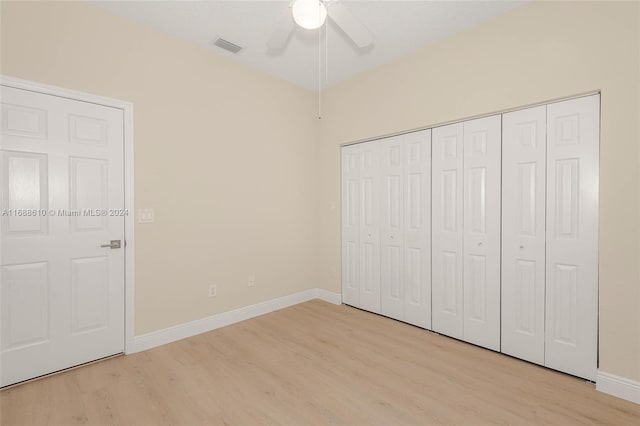 unfurnished bedroom featuring a closet, light wood-type flooring, and ceiling fan