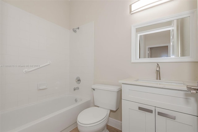 full bathroom featuring vanity, tiled shower / bath combo, and toilet