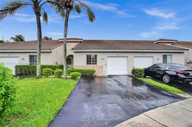 view of front of property with a garage and a front lawn