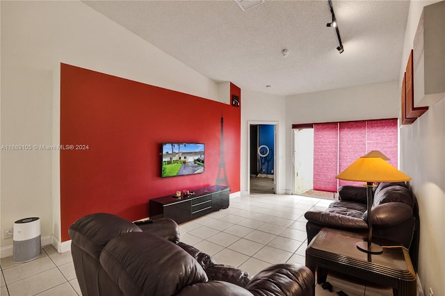 living room with a textured ceiling, rail lighting, and light tile patterned flooring