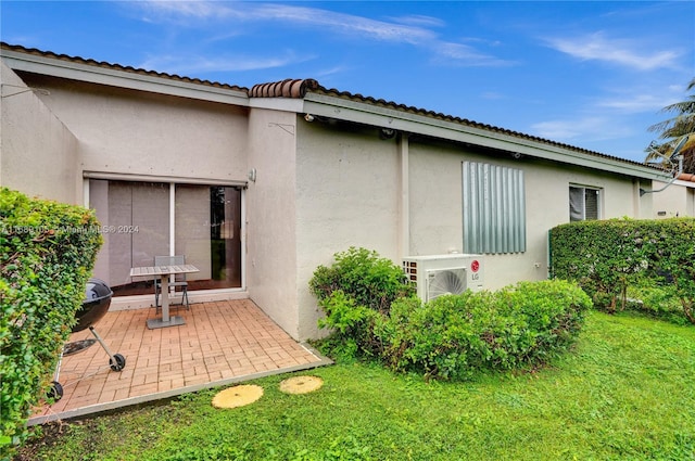 back of house featuring a patio, a lawn, and ac unit