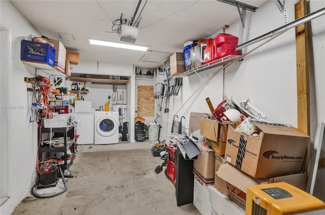 garage with separate washer and dryer and a garage door opener