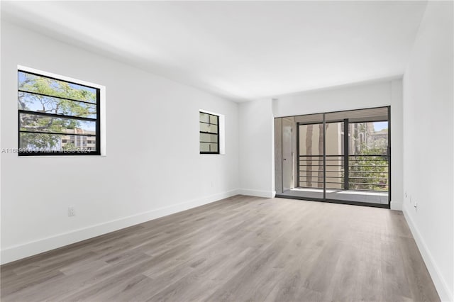 unfurnished room with a wealth of natural light and light hardwood / wood-style floors