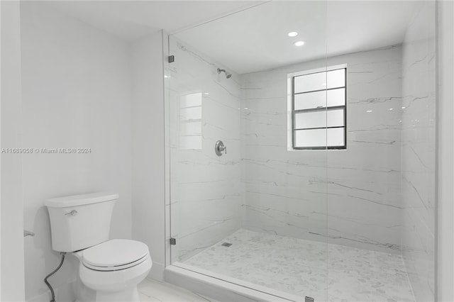 bathroom featuring toilet and a tile shower