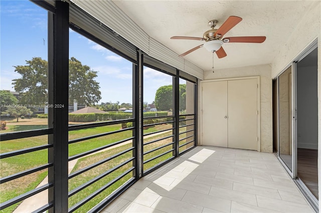 unfurnished sunroom with ceiling fan