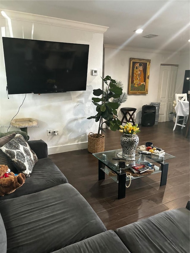 living room featuring dark hardwood / wood-style floors and crown molding