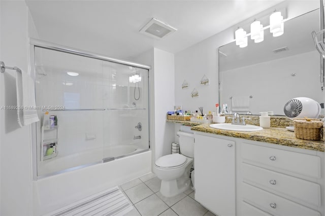 full bathroom featuring bath / shower combo with glass door, tile patterned flooring, vanity, and toilet