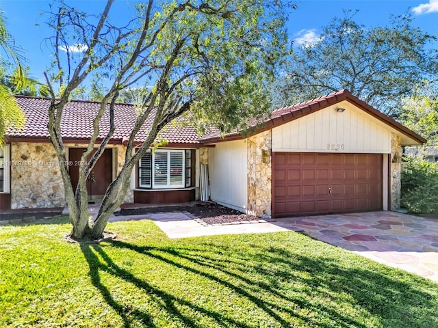 single story home featuring a garage and a front lawn