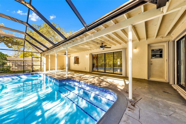 view of pool featuring glass enclosure, ceiling fan, and a patio area