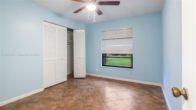 unfurnished bedroom with ceiling fan and a closet