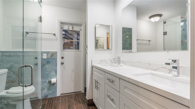 bathroom with hardwood / wood-style floors, vanity, toilet, and an enclosed shower