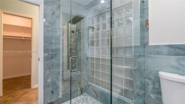 bathroom with tile patterned floors, toilet, and walk in shower