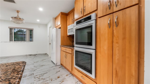 kitchen with dark stone countertops and white appliances