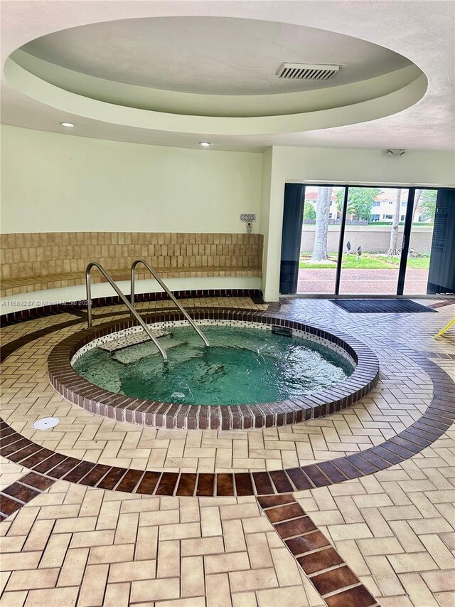 view of pool with an indoor hot tub