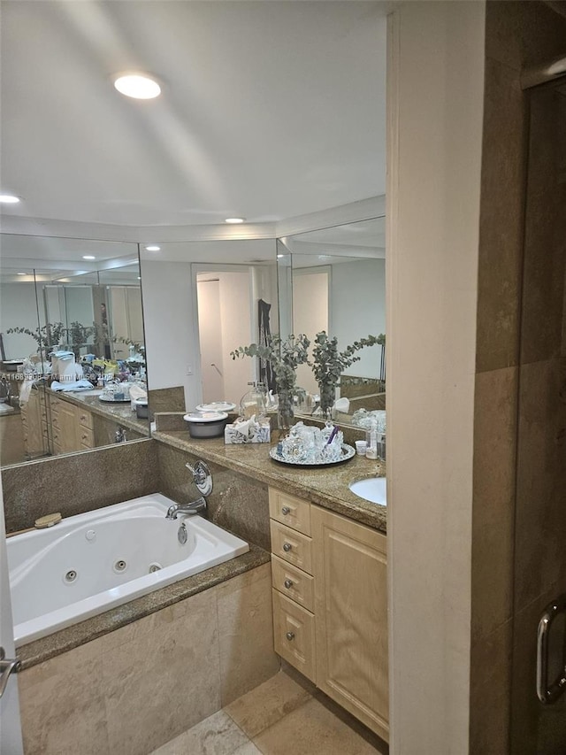 bathroom featuring tiled bath and vanity