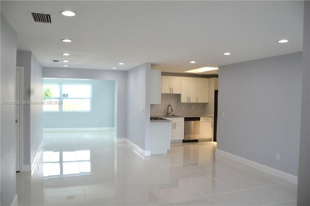 kitchen with tasteful backsplash, white cabinetry, light tile patterned floors, and stainless steel dishwasher