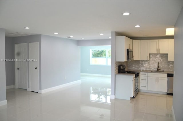 kitchen featuring stainless steel appliances, white cabinetry, sink, and backsplash