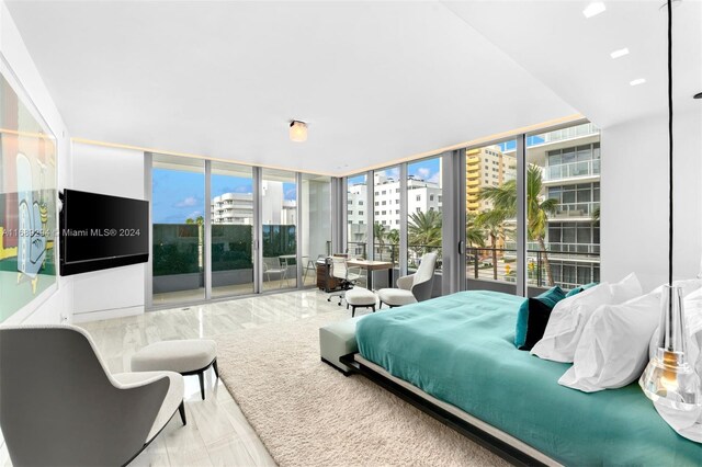 bedroom featuring floor to ceiling windows, access to outside, and multiple windows