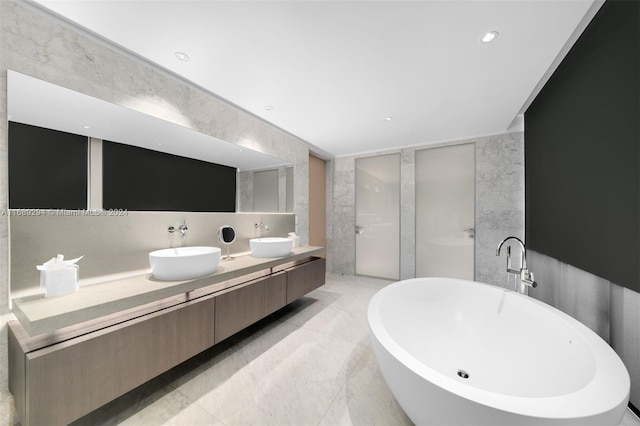 bathroom featuring vanity, a bathtub, and tile walls