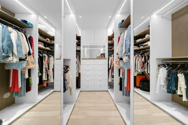 walk in closet with light hardwood / wood-style floors