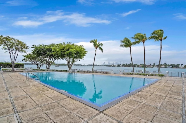 view of pool featuring a water view and a patio