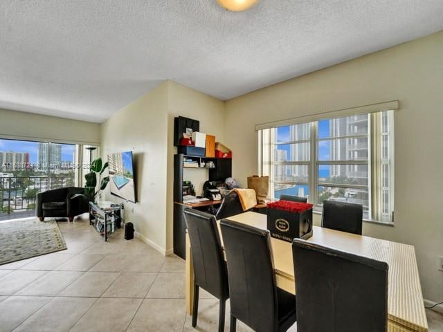 dining space with light tile patterned flooring and a textured ceiling