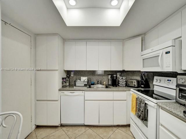 kitchen with white cabinets, sink, and white appliances