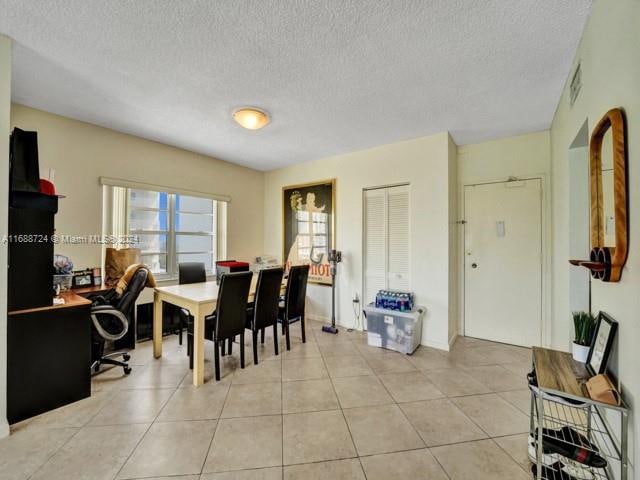 dining room with a textured ceiling and light tile patterned floors