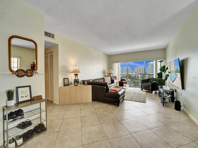 tiled living room featuring a textured ceiling