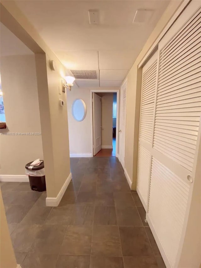 hall with dark tile patterned floors