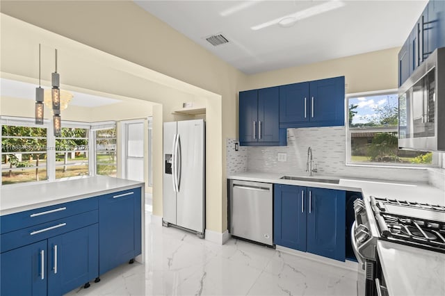 kitchen with sink, pendant lighting, appliances with stainless steel finishes, and blue cabinets