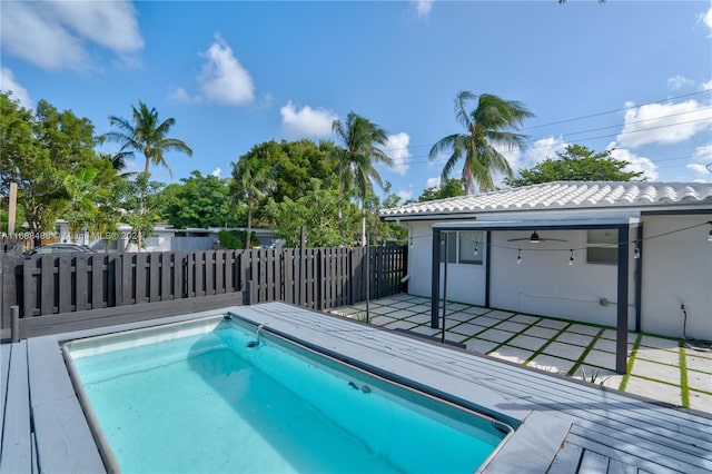 view of pool with ceiling fan and a deck