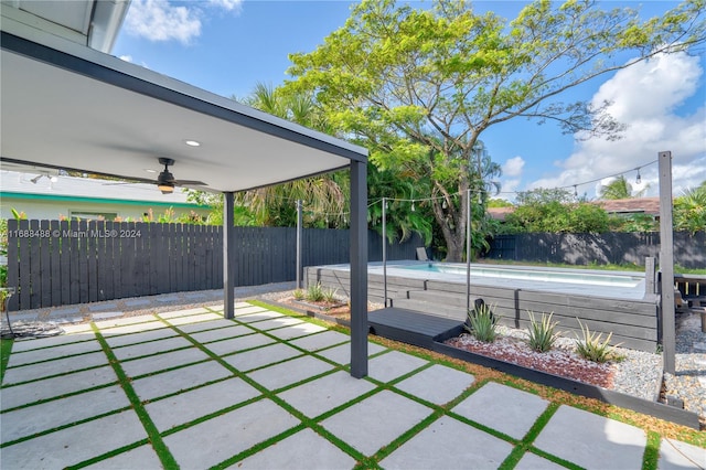 view of patio with ceiling fan and a fenced in pool