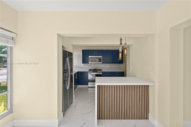 kitchen featuring blue cabinetry, appliances with stainless steel finishes, backsplash, and kitchen peninsula